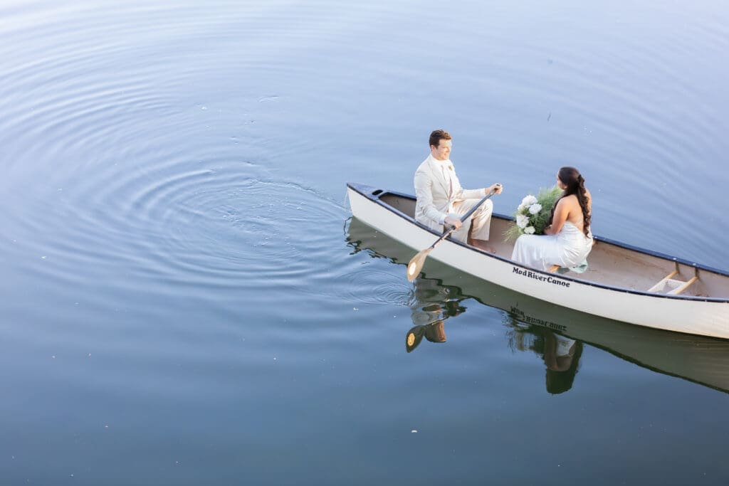 A couple paddles a canoe on their wedding day at Whispering Oaks Lodge in Moab, UT